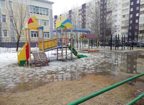 В Сургуте из-за таяния снега затопило детскую площадку ‒ УК проблему не решает
